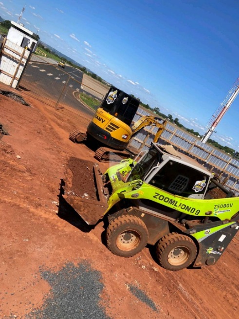 Mini carregadeira e mini escavadeira em obra de terra